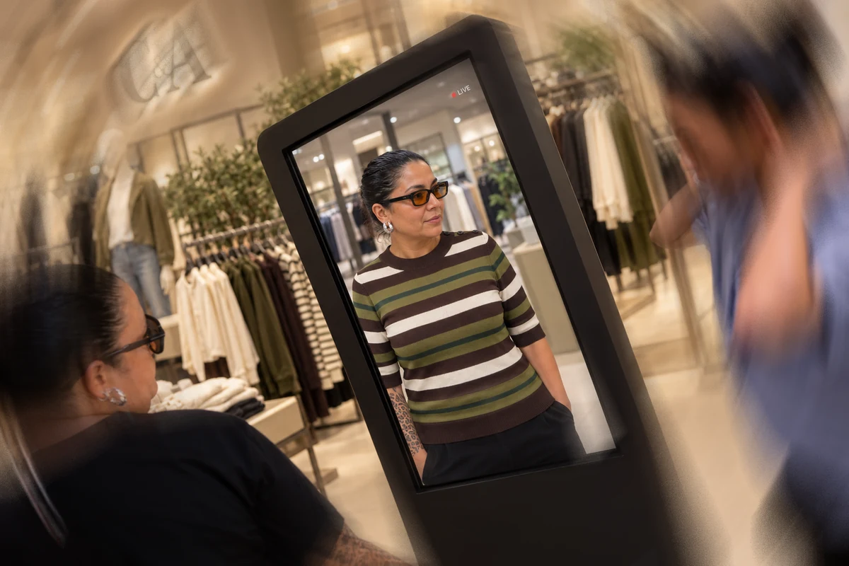 Pessoa se vendo com um look listrado no espelho virtual